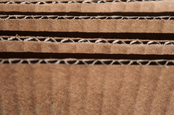 Texture of layered brown cardboard side. Folded cardboard boxes.