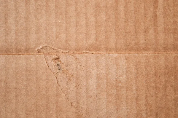 Textura da caixa de papelão marrom danificada limpa. Papel ondulado dobrado — Fotografia de Stock