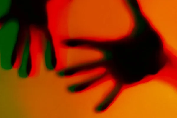 Hands in orange and green neon light gradient behind white surface. Foggy blurred effect for different concept ideas. — Stock Photo, Image