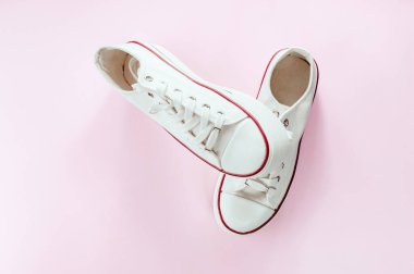 Krem pembeli beyaz spor ayakkabılar. Düz yerde, üst tarafta. Mesaj için yer. Asgari biçim kompozisyonu.