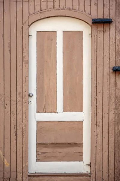 Białe drzwi w drewnianej ścianie — Zdjęcie stockowe