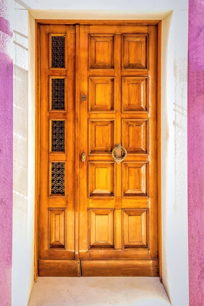 Деревянная дверь на розовой стене — стоковое фото