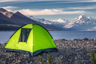Yeşil çadır Pukaki buzul Gölü turkuaz mavi su ve dağlar manzara ile bakan dağlar odaklı. Dağ manzarası kar ve buzul Gölü ile kış. Pukaki gölde Aoraki - Mount Cook Milli Parkı, Yeni Zelanda.