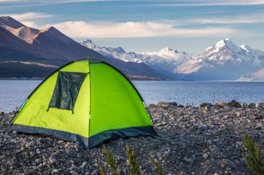 Yeşil çadır Pukaki buzul Gölü turkuaz mavi su ve dağlar manzara ile bakan dağ odaklı. Dağ manzarası kar ve buzul Gölü ile kış. Pukaki gölde Aoraki - Mount Cook Milli Parkı, Yeni Zelanda.