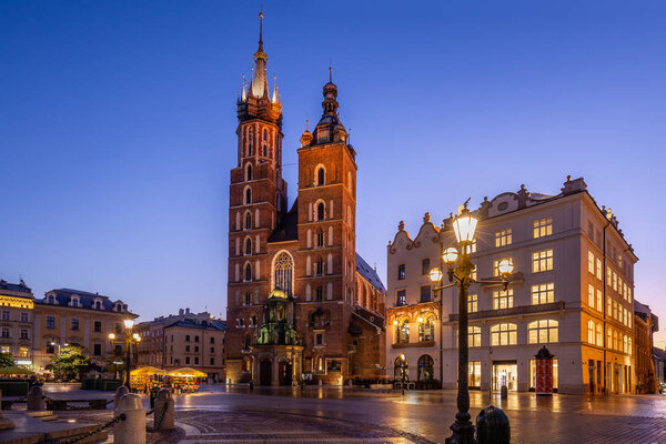 Market Square at sunrise in old city center at Krakow at morning time, main square, famous cathedral at sunrise in Krakow, Poland.