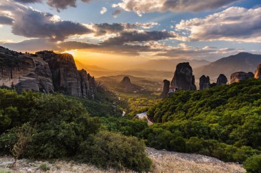 Manastır Meteora Yunanistan. Yaz panoramik manzara çarpıcı. Dağlar ve epik mavi gökyüzü bulutlu yeşil orman görüntüleyin. UNESCO miras listesi nesnesi.