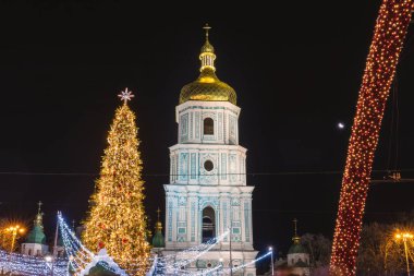 Kiev 'de geceleri ışıkları açık olan bir Noel ağacı. Arkadaki Sophia Katedrali. Kiev, Ukrayna 'da yeni yıl kutlaması. Noel pazarı. Ayarlanmış.