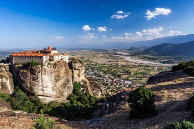 Manastır Meteora Yunanistan. Yaz panoramik manzara çarpıcı. Dağlar ve epik mavi gökyüzü bulutlu yeşil orman görüntüleyin. UNESCO miras listesi nesnesi.