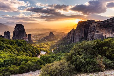 Manastır Meteora Yunanistan. Yaz panoramik manzara çarpıcı. Dağlar ve epik mavi gökyüzü bulutlu yeşil orman görüntüleyin. UNESCO miras listesi nesnesi.