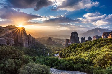 Manastır Meteora Yunanistan. Yaz panoramik manzara çarpıcı. Dağlar ve epik mavi gökyüzü bulutlu yeşil orman görüntüleyin. UNESCO miras listesi nesnesi.