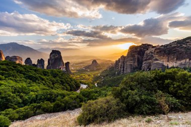 Manastır Meteora Yunanistan. Yaz panoramik manzara çarpıcı. Dağlar ve epik mavi gökyüzü bulutlu yeşil orman görüntüleyin. UNESCO miras listesi nesnesi.