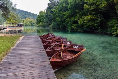 Hırvatistan 'ın Plitvice Lakes kentindeki dünyanın en şaşırtıcı yerlerinden birinin şelaleleri yakınındaki ahşap botlar. Gerçekten bakire ve doğanın harika bir parçası..