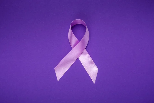 October is Breast Cancer Awareness Month. Pink Ribbon for supporting people living and illness. Healthcare, International Women day and World cancer day concept. On purple background.