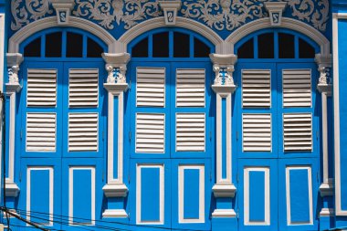 Pencerelerdeki ahşap panjurlar farklı şekillerde. Tayland 'ın eski Phuket kasabasındaki renkli binalar. Sino Portekiz tarzı.