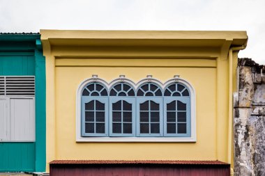Pencerelerdeki ahşap panjurlar farklı şekillerde. Tayland 'ın eski Phuket kasabasındaki renkli binalar. Sino Portekiz tarzı.