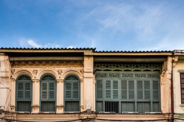 Pencerelerdeki ahşap panjurlar farklı şekillerde. Tayland 'ın eski Phuket kasabasındaki renkli binalar. Sino Portekiz tarzı.