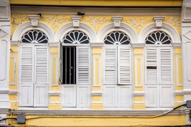 Pencerelerdeki ahşap panjurlar farklı şekillerde. Tayland 'ın eski Phuket kasabasındaki renkli binalar. Sino Portekiz tarzı.