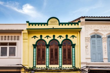 Pencerelerdeki ahşap panjurlar farklı şekillerde. Tayland 'ın eski Phuket kasabasındaki renkli binalar. Sino Portekiz tarzı.