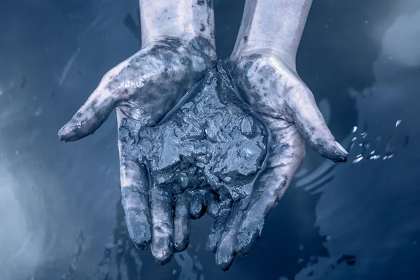 イスラエルの死海で治癒力を持つ死海の泥を手に持つ少女の手 ブルートーニング — ストック写真