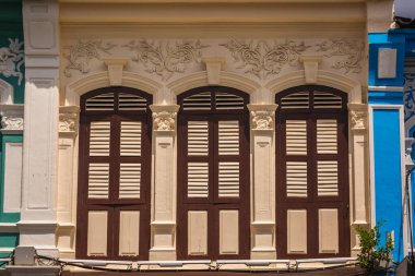 Pencerelerdeki ahşap panjurlar farklı şekillerde. Tayland 'ın eski Phuket kasabasındaki renkli binalar. Sino Portekiz tarzı.