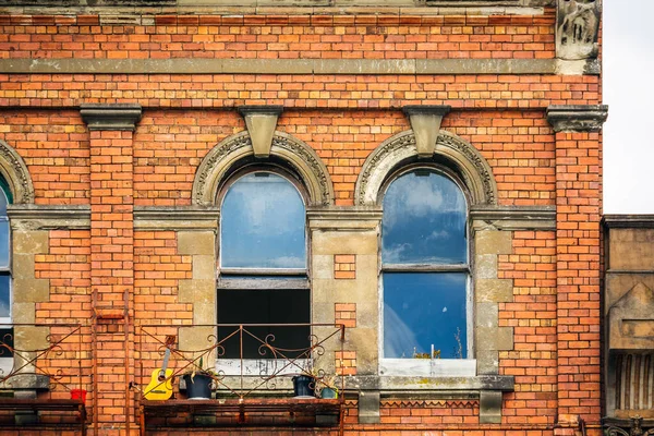 Side wall of vintage brick building with windows in Auckland, New Zealand.