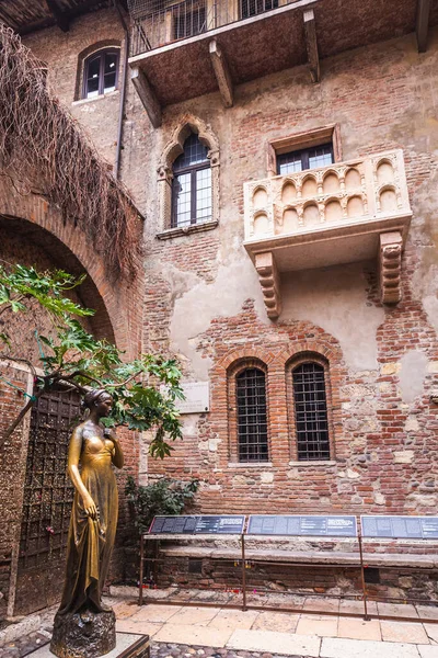 Patio and balcony of Romeo and Juliet house at golden sunset, Verona, Italy. Bronze statues of Juliet.