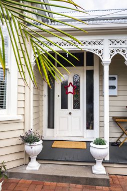 Auckland, Yeni Zelanda 'nın kapısında palmiye ağacı ve Noel yıldızı olan klasik ahşap bir bina duvarı..