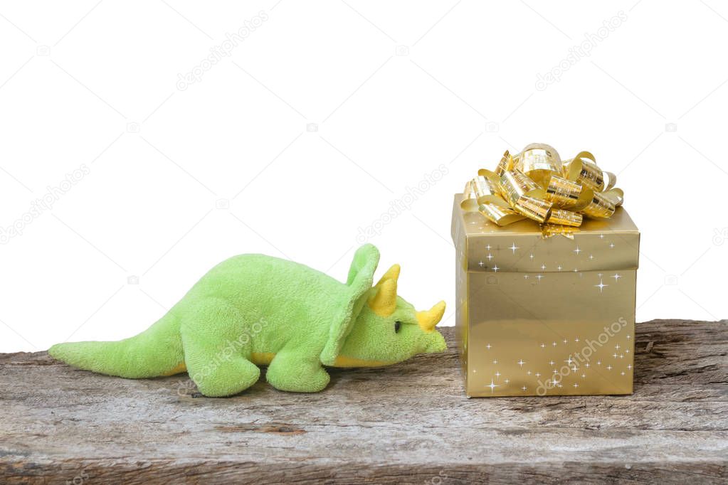 dinosaur toy and the gold box on wood background
