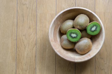 Kivi meyve bir kase ahşap arka plan üzerinde