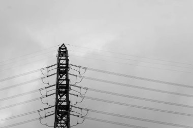 Bulutlar ve almak tek renkli tarzı bir fotoğraf çekimi ile yüksek gerilim kuleleri