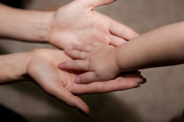 Anne ona çocuğun elini tutarak