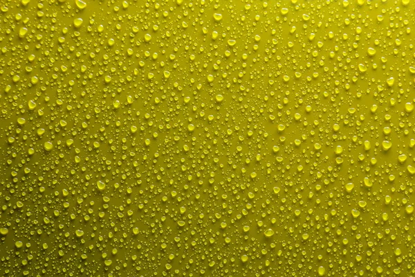 Gocce d'acqua su giallo — Foto Stock