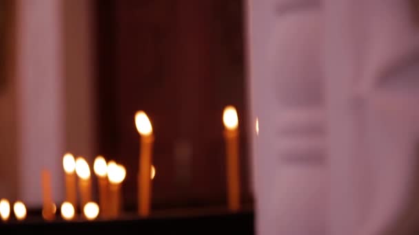 Всередині є Православна церковного свічки спалювання приходять на світло свічки ікони в церкві — стокове відео