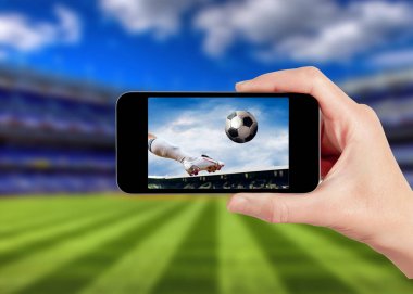 Futbol oyun üstünde hareket eden telefon