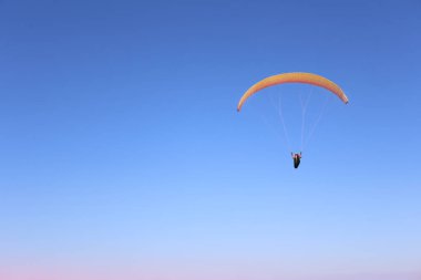 Gökyüzünde bir Yamaçparaşütü üzerinde uçan bir adam