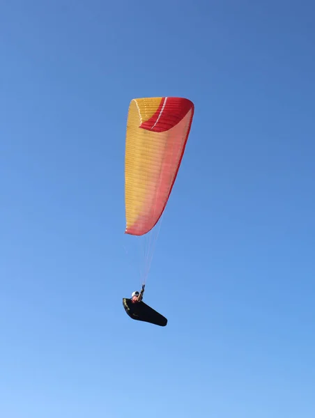 Um homem está voando em um parapente no céu — Fotografia de Stock