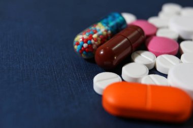 Renkli hapları closeup bir koyu mavi arka plan, sağlık ve tıp kavramı