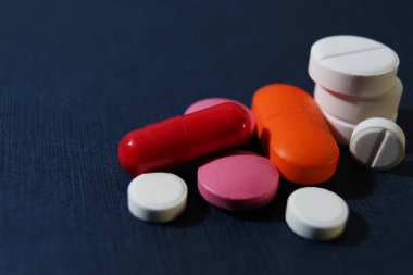 Renkli hapları closeup bir koyu mavi arka plan, sağlık ve tıp kavramı