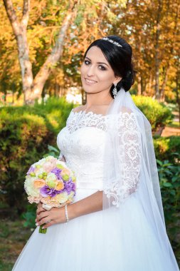 güzel gelin düğün gününde güzel bir buket ile sonbahar orman arka plan