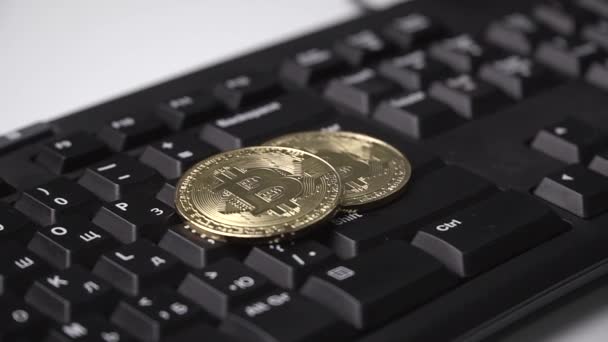 Złota moneta Bitcoin kręci się na klawiaturze — Wideo stockowe