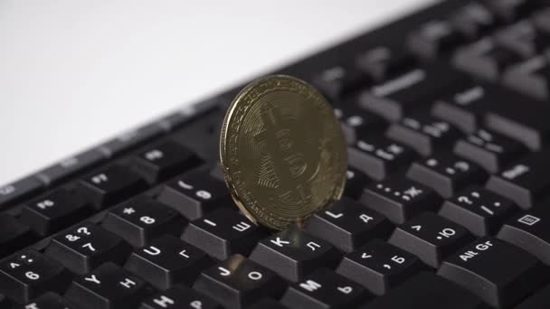 Zlatá mince Bitcoinu točí na klávesnici — Stock video