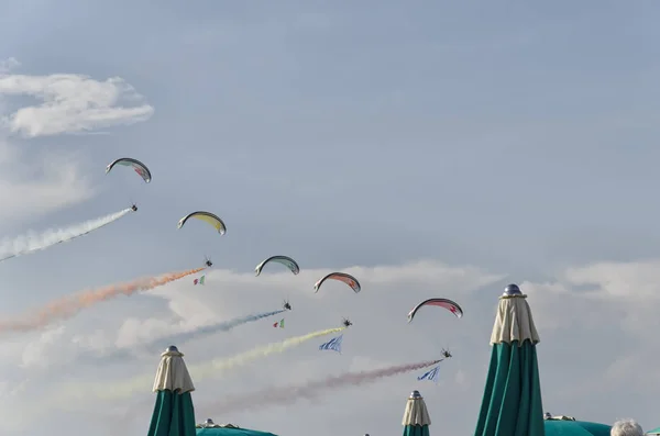 Paramotors z kolorowych szlaków dymu w paradzie na plaży — Zdjęcie stockowe