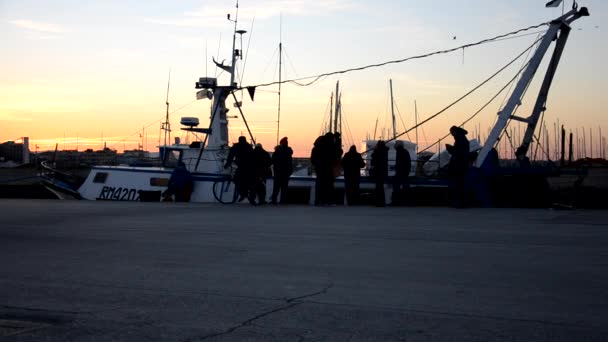 Люди ждут свежую рыбу у рыболовецкого судна — стоковое видео