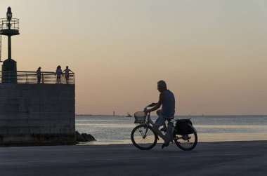 İnsanlar gün batımında iskelede