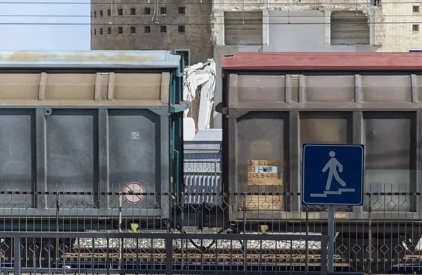 Treno merci che passa davanti a un edificio — Foto Stock