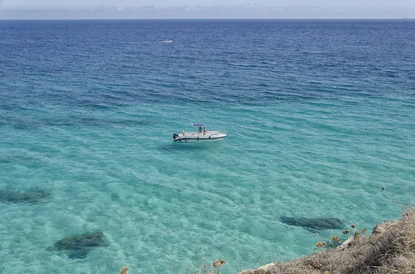 Les gens dans un bateau dans la magnifique mer du Salento Images De Stock Libres De Droits