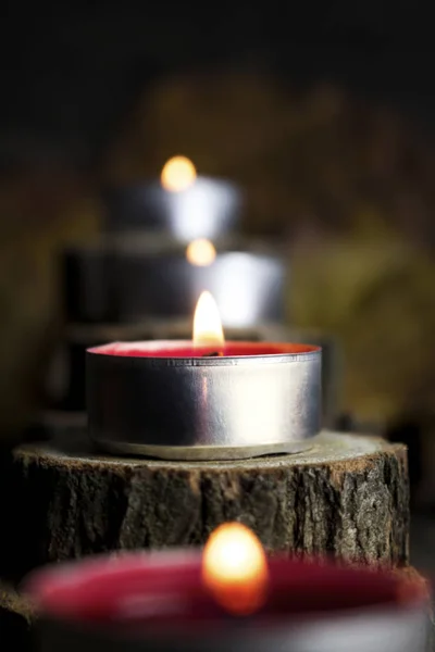 Velas de Navidad ardiendo, decoración con troncos de madera descansando sobre fondo de madera —  Fotos de Stock