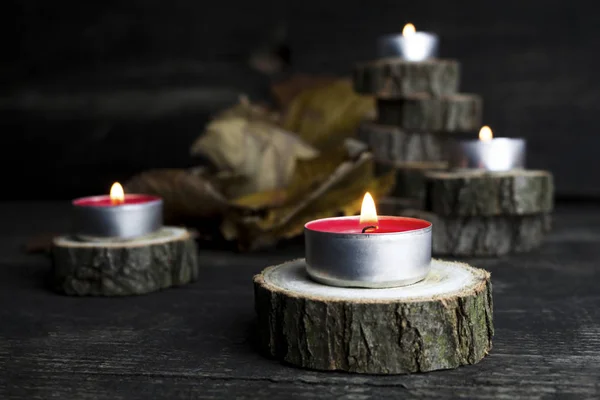 Velas de Navidad ardiendo, decoración con troncos de madera descansando sobre fondo de madera —  Fotos de Stock