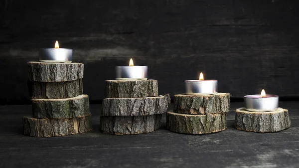 Різдвяні свічки, що горять, прикраса дерев'яними колодами, що спираються на дерев'яний фон — стокове фото