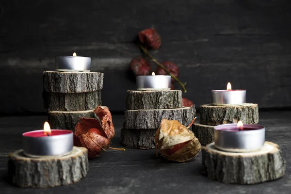Velas de Navidad ardiendo, decoración con troncos de madera descansando sobre fondo de madera —  Fotos de Stock